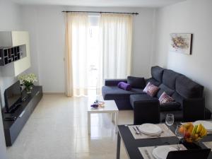 a living room with a blue couch and a table at Puesta de Sol Rentals 3AR in Playa de San Juan