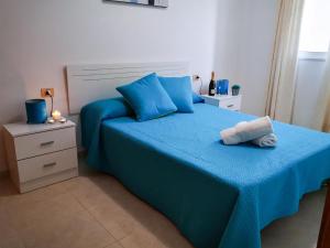 a bedroom with a blue bed with blue pillows at Puesta de Sol Rentals 3AR in Playa de San Juan