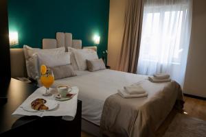 a bedroom with a large bed with a tray of food on it at Boutique Hotel Bura 45N in Senj