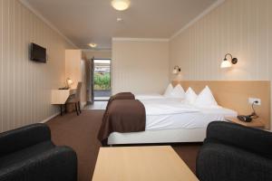 une chambre d'hôtel avec un lit et deux chaises dans l'établissement Hotel Raudaskrida, à Þóroddsstaður