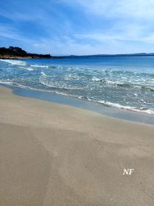 uma praia com as palavras nir escritas na areia em A cà du Sepino a due passi dal mare em Carloforte