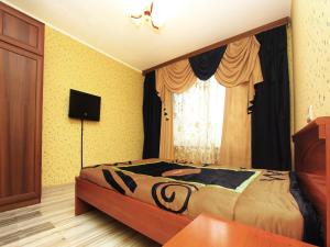 1 dormitorio con 1 cama, TV y ventana en ApartLux Taganskaya Suite, en Moscú