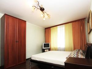 1 dormitorio con 1 cama, vestidor y TV en ApartLux Taganskaya Suite, en Moscú