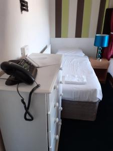 a phone sitting on a desk next to a bed at The Coastal Bay Hotel in Blackpool