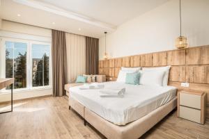 een slaapkamer met een groot bed en een groot raam bij Hotel Olea in Ulcinj