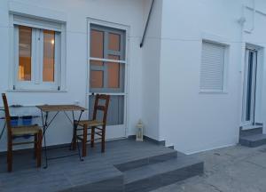 a patio with two chairs and a table and a window at Marina's House in Triovasálos