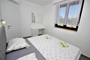 Habitación blanca pequeña con cama y ventana en Apartments Smitran, en Banjole