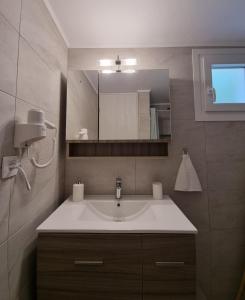 een badkamer met een wastafel en een spiegel bij Marina's House in Triovasálos