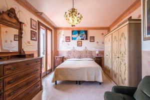 a bedroom with a bed and a chandelier at Villa Vanna - Certaldo in Vico dʼElsa