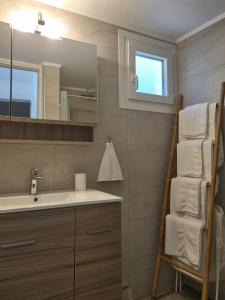een badkamer met een wastafel, een spiegel en handdoeken bij Marina's House in Triovasálos