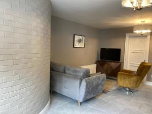 uma sala de estar com um sofá e duas cadeiras em Highgrange Apartments em Dundalk