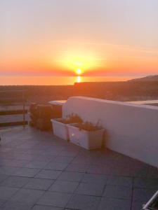 a sunset over the ocean with two planters on a wall at Dammuso Cinzia, incantevole fronte mare in Pantelleria