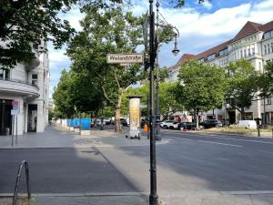 a street sign on a pole on a city street at Hotel Castell am Kurfürstendamm in Berlin