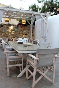 a wooden table and chairs under an umbrella at Cozy house with relaxing backyard in Ermoupoli