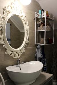 a bathroom with a white sink and a mirror at Cozy house with relaxing backyard in Ermoupoli +23 photos