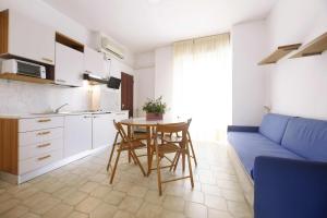 uma sala de estar com uma mesa e um sofá azul em Residence Barusso em Alassio