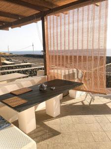 a picnic table sitting on top of a building at Dammuso Cinzia, incantevole fronte mare in Pantelleria