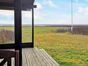a screened in porch with a view of a field at 5 person holiday home in Harbo re in Harboør