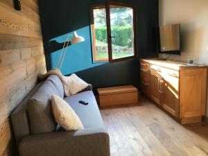 ein Wohnzimmer mit einem Sofa und einem Fenster in der Unterkunft Duplex Bellevue in Gérardmer
