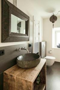a bathroom with a large stone sink on a wooden table at Modern-bayrisches Apartment mit Seeblick in Tegernsee