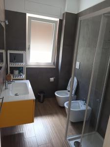 a bathroom with two sinks and a toilet and a shower at Casa simone 2 in Conversano
