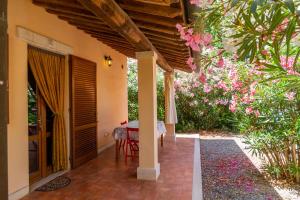 um alpendre de uma casa com uma mesa e flores em Bilo Iris em Marina di Grosseto