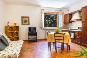 uma cozinha e sala de estar com mesa e cadeiras em Bilo Iris em Marina di Grosseto