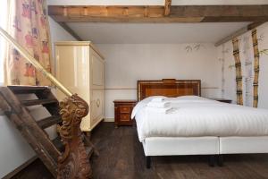 Un dormitorio con una cama blanca y una escalera. en The Loft 300 - R Q C, en La Haya