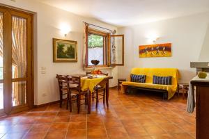 een woonkamer met een tafel en stoelen en een bank bij Bilo Erica in Marina di Grosseto
