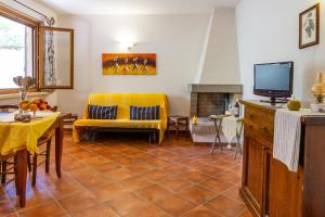 a living room with a yellow couch and a tv at Bilo Erica in Marina di Grosseto