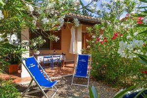 a patio with two blue chairs and a table at Bilo Erica in Marina di Grosseto