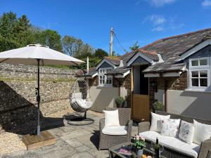 ドーチェスターにあるThe Coach House at Lackington Farmのパティオ(椅子2脚、パラソル付)