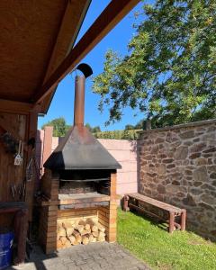 an outdoor brick oven with a bench next to a wall at Holiday Home Křesánov in Vimperk