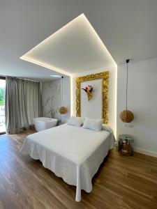 1 dormitorio con cama blanca y bañera en VISTA LAGO VILLE, en Chiclana de la Frontera