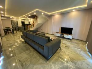 ein Wohnzimmer mit Sofa und Fernseher in der Unterkunft Özel havuzlu lüks villa in Kusadası
