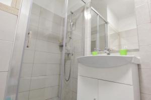 biała łazienka z umywalką i prysznicem w obiekcie Studio Jana Umag w mieście Umag