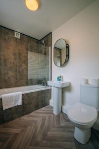 a bathroom with a sink and a toilet and a tub at Barron House By Horizon Stays in Darlington