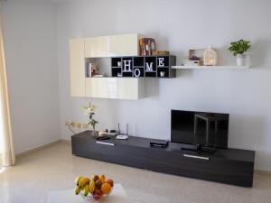 a living room with a television and a bowl of fruit at Puesta de Sol Rentals 3DR in Playa de San Juan