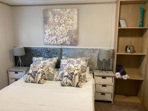 Un dormitorio con una cama con almohadas y una pintura en Ashford Heights en Barnstaple