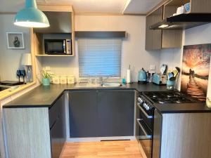 a kitchen with a sink and a stove top oven at Ashford Heights in Barnstaple