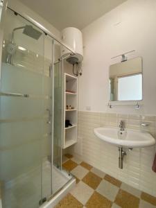y baño con lavabo y ducha acristalada. en Rossocorallo Rooms, en Alghero