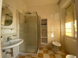 uma casa de banho com um chuveiro, um lavatório e um WC. em Rossocorallo Rooms em Alghero