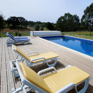 a deck with chairs and a swimming pool at Monte dos Cachoupos in São Luis