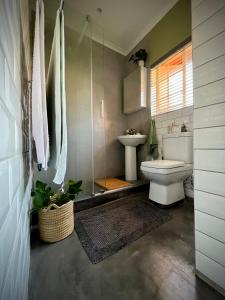 a bathroom with a toilet and a sink at Spacious 2-bed, 2-bath villa with garden and parking in Mataffin