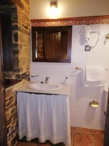 a bathroom with a sink with a shower curtain at Pajar in Braña