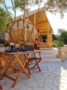 a picnic table in front of a house at AURAS - Glamping Eco Resort in Biograd na Moru