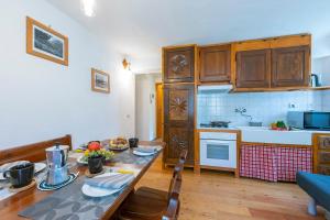 a kitchen with a dining room table and a table and chairs at Miramonti 21 Ski In - Ski Out - Happy Rentals in Sauze dʼOulx
