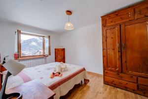 a bedroom with a bed and a dresser and a window at Miramonti 21 Ski In - Ski Out - Happy Rentals in Sauze dʼOulx