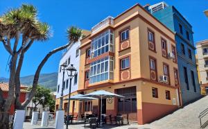San PedroにあるLa Casita del Arco Panorámicoの傘の前の建物