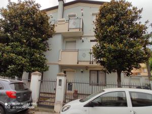 a white car parked in front of a building at APPARTAMENTI RIMINI NEL CUORE in Rimini